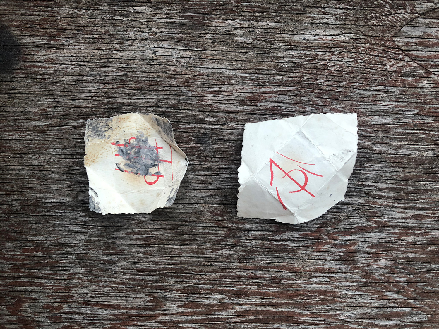 Two sigils written in red ink on paper