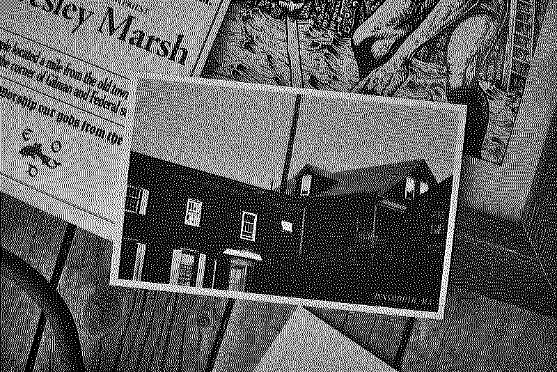 Close-up photo of the front of the postcard showing old buildings