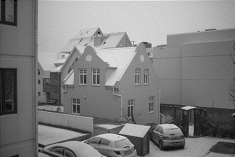 An adorable small mint green house under the snow